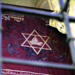 54-55-wikipedia-prague_praha_2014_holmstad_-_den_gammelnye_synagogen_-_old-new_synagogue_-_josefov_-_banner_with_jewish_hat